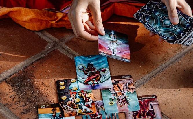 Hands arranging tarot cards